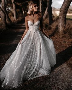 a woman in a white dress is walking down the road