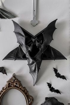 some bats are hanging on the wall next to a mirror and framed photo with an ornate frame