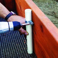 a person using a drill to fix a wooden fence