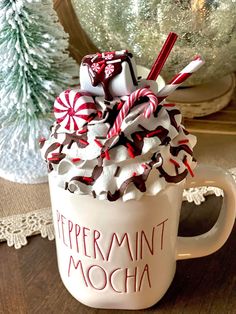 a cup filled with whipped cream and candy canes sitting on top of a table