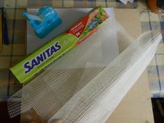 a piece of white mesh sitting on top of a table next to a tube of toothpaste