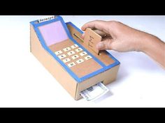 a cardboard box that has a calculator in it and someone's hand