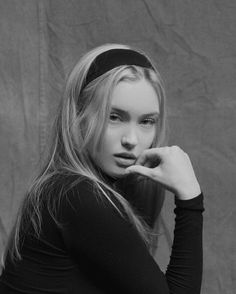 black and white photograph of a woman with long blonde hair wearing a headband looking at the camera