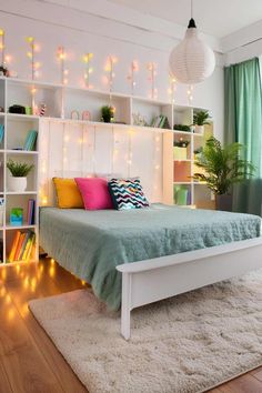 a white bed sitting in a bedroom next to a book shelf filled with lots of books