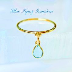 This Blue Topaz Engagement Ring features a teardrop gemstone, handcrafted in 14k gold-filled and perfect as a December birthstone for jewelry lovers. Available in sizes 4-8, this unique handmade dangling charm ring is an elegant gift for her. 💍  ✦100% handcrafted ✦ High quality 14k yellow gold-filled and light blue topaz gemstone ✦ Ring arrives in either a pink microfiber suede envelope/pouch or a blue/green drawer cardboard box as seen in the last image of this listing. ✦ Ready to ship in one business day ✦ Average shipping time (US/Canada/UK) three to five business days  ✦ Tracking available ✦Pear-shaped blue topaz gemstone bezel encased in a 14k gold frame Size--4mmx6mm Color-blue Shape--pear Material--14k yellow gold and blue topaz gemstone ✦Band Style--2mm textured, 2mm smooth or 1mm Fine Jewelry Yellow Gold Topaz Teardrop Ring, Fine Jewelry Yellow Gold Topaz Ring With Teardrop, Anniversary Yellow Gold Teardrop Topaz Ring, Gold Teardrop Birthstone Ring For Anniversary, Teardrop Topaz Ring For Anniversary, Anniversary Teardrop Topaz Ring, Teardrop Blue Topaz Ring Gift, Gold Teardrop Birthstone Ring, Fine Jewelry, Teardrop Topaz Ring Gift