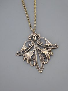 "Vintage Jewelry - Art Nouveau Necklace - Vintage Necklace - Vintage Brass Necklace - French Brass Necklace - Chloe's Vintage Jewelry This is such an exquisite vintage necklace! A gorgeous, graceful floral leaf design. Wonderful warm patina and detail. So very feminine Chloe says, \"Wear it and feel fabulous!\" The pendant measures 2 1/4\" long and 2\" wide. You can choose the necklace length you would like at checkout. Thanks for visiting Chloe's" Decorative Antique Gold Necklaces For Gifts, Decorative Antique Gold Necklace For Gift, Ornate Bronze Necklace As Gift, Ornate Bronze Necklace For Gifts, Ornate Bronze Necklace For Gift, Art Nouveau Necklace With Intricate Design For Gift, Artistic Jewelry With Intricate Design For Gift, Nickel-free Gold Art Nouveau Jewelry, Gold Nickel-free Art Nouveau Jewelry