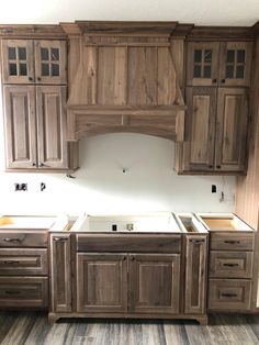 a kitchen that has wooden cabinets and drawers in the middle with no doors on them