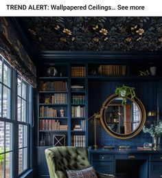 a room with blue walls and bookshelves has a green chair in the corner