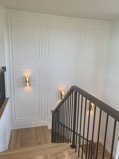 an empty room with some lights on the wall and wood flooring in front of it