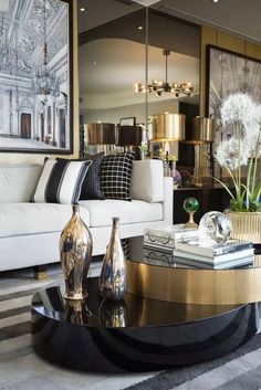 a living room with white couches and gold accents on the tables in front of them