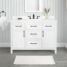 a white bathroom vanity with two sinks and mirrors