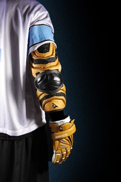 a person wearing yellow and black gloves holding a baseball glove on their left arm,