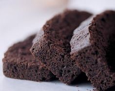 three pieces of chocolate brownie sitting on top of each other, with one piece cut in half