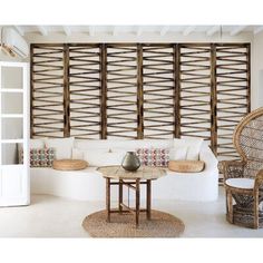 a living room filled with furniture and lots of wood slats on the wall behind it