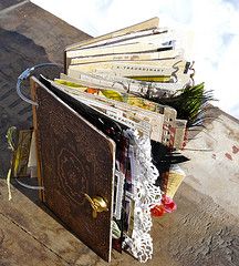 an open book sitting on top of a wooden table next to a pile of books