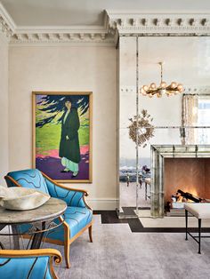 a living room filled with furniture and a painting on the wall above a fire place