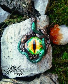 Medusa's Eye pendant with green and bronze snakes. Handmade with lots of details, this powerful necklace will surely leave everyone petrified.    #Medusa #EvilEye #SnakeJewelry #MedusaNecklace #Handmade #Fimo Handmade Mystical Green Jewelry, Mystical Handmade Green Jewelry, Unique Green Snake-shaped Jewelry, Handmade Green Mystical Jewelry, Green Handmade Mystical Jewelry, Handmade Green Fantasy Necklaces, Handmade Fantasy Green Necklaces, Green Amulet Necklace Collectible, Handmade Green Fantasy Necklace