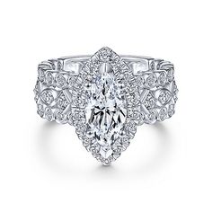 a white gold engagement ring with an oval cut diamond surrounded by round brilliant pave diamonds