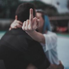 a man and woman making the peace sign with their hands while standing next to each other