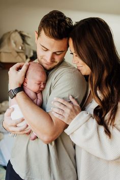 a man and woman holding a baby in their arms