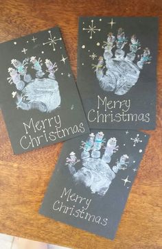 three handprinted christmas cards on top of a wooden table