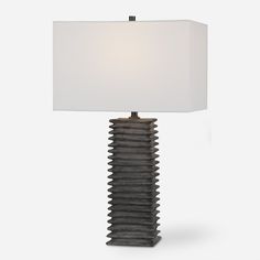 a table lamp with a white shade on it's side and a black base