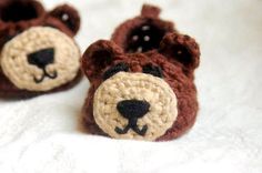 two small crocheted teddy bears laying on top of a bed next to each other