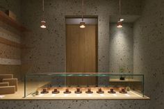 an empty display case in a room with wooden shelves and lights hanging from the ceiling