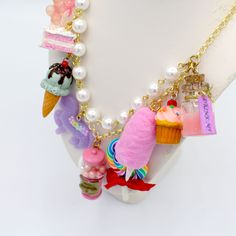 This kawaii statement necklace is called Pink Candy Shop and is a perfect cute charm jewelry gift for any woman in your life including your best friend (or yourself, let's be honest). This piece has been handmade from resin, clay and high quality metal components and features hand painted charms for a quality piece that will be a cute go-to in any charm lovers jewelry collection! Details & Measurements:-Handmade Necklace-High quality glass pearls-Hand-painted charms made from resin & polymer clay-Gumball machine has free floating beads inside! (note it is partially made from glass and fragile)-Choose Gold or Silver Finish -Choose 5, 7 or 9 charms (see list below to find out what charms come on each option)-Charms are chunky and are 1-2" in size (2.5-5cm)-19" (47.5cm) total Necklace Length- Handmade Dangle Charm Necklaces For Birthdays, Playful Dangle Necklaces With Charms, Playful Dangle Charms Necklace, Playful Dangle Charm Necklace, Cute Multicolor Pendant Jewelry, Whimsical Charms Necklace For Birthday, Whimsical Charms Necklace For Birthdays, Kawaii Charms Jewelry For Gift, Cute Jewelry With Lobster Clasp For Gifts