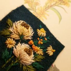 an embroidered piece of cloth with flowers on it