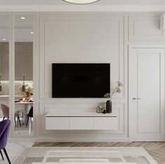 a living room with a flat screen tv mounted on the wall next to a dining table