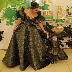 a woman and child dressed in green dresses