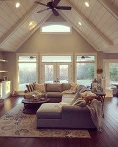 a living room filled with furniture and a ceiling fan in the middle of an open floor plan