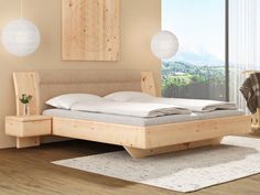 a bed sitting on top of a wooden floor next to a window