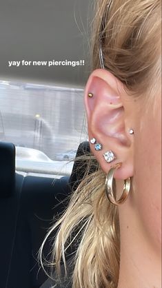 a woman with ear piercings in the back seat of a car