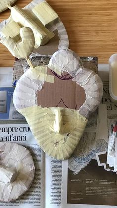 some paper plates are sitting on top of a newspaper and next to a glass of milk