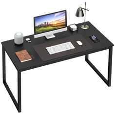 a computer desk with a monitor, keyboard and mouse next to a cup on it