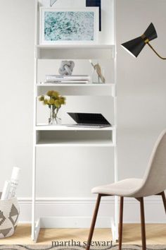 a room with a chair, desk and bookshelf on the wall next to it