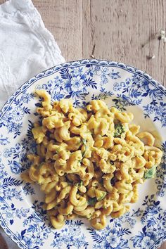 a blue and white plate topped with macaroni and cheese