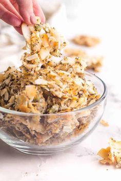 someone is scooping something out of a glass bowl with other food items in it