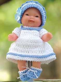 a baby doll wearing a white dress and blue bonnet