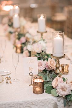 the table is set with candles, flowers and place cards for guests to sit at