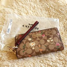 Gorgeous New With Tags Coach Signature Wildflower Long Zippered Wallet/Wristlet Is In Excellent New Condition. Beautiful Brown Signature Polycoated Leather With Multi-Colored Floral Design And Gold Logo Badge And Hardware. 3/4 Zipper With Accordian Pleats For Easy Access. Center Zippered Section That Divides The Wallet Into 2 Compartments. Lots Of Credit Card Slots And Storage. Wristlet Strap Can Be Removed To Use As Clutch Or Wallet. All Paperwork Is Included. Wallet Measures Approximately 7 1/ Edna Mode, Chanel Perfume, Cute Wallets, Wallet Wristlet, Logo Badge, Coach Wristlet, Zip Wallet, Gold Logo, Suitcases