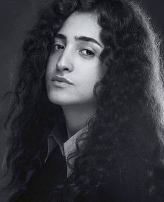 a black and white photo of a woman with long curly hair