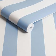 a blue and white striped wallpaper with a roll of toilet paper on the floor