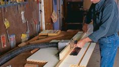 a man working on some wood in his workshop