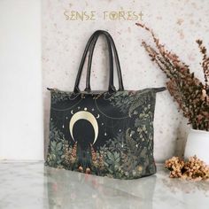 "Cottagecore Lush forest Witchy moon handbag, Whimsical boho fern zip tote , Pagan Witch Occult aesthetic art bag with vegan leather handles      Oxford Fabric, 15\"(L) x 7\"(W) x11.4\"(H) x 7.6\"(Handle), Two Sides Printing     14.46 Oz. Made from durable oxford fabric.     Metal button closure.      Dimensions: 15\"(L) x 7\"(W) x 11.4\"(H) x 7.6\"(handle).     Large capacity. It contains 1 main large compartment and small zipper pocket. ❣️PRODUCTION and DELIVERY TERMS: This item will be shipped out from China The production takes 5-7  business days International delivery time is 10-20 business days. Ref:810 Sense Forest would like to provide some clarity regarding the creation of our designs. We take pride in crafting all our designs in our dedicated workshop located in Las Vegas, USA. F Cottagecore Handbag, Witchy Backpack, Forest Fairy Bag, Occult Aesthetic, Witchy Purse, Witchy Handbag, Gothic Tote Shoulder Bag For Everyday Use, Lush Forest, Pagan Witch