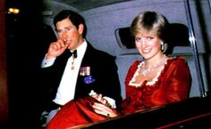 a man and woman sitting in the back seat of a car, dressed in red