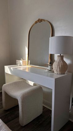 a white dressing table with a mirror and stool