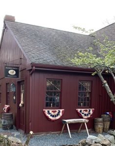 a small red building with two flags on the front and one flag on the back